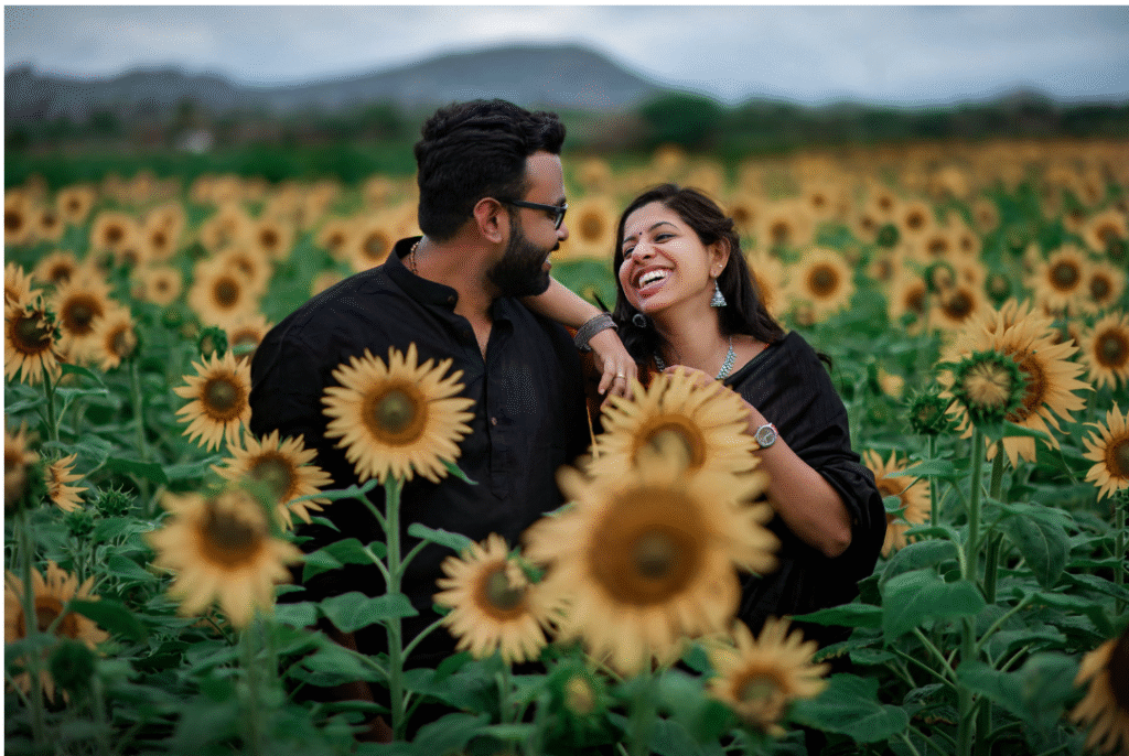 Couple laughing in a sunflower field, a candid moment of wedding photography in Trivandrum